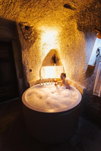 a man sitting in a bath tub in a barrel at Angel View Suites in Goreme