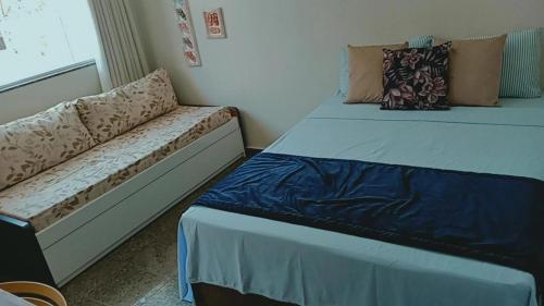 a small bedroom with two beds and a couch at Segunda Casa- Seu cantinho na Praia do Morro em Guarapari - Quartos suítes 2 até 4 pessoas in Guarapari