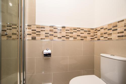 a bathroom with a toilet and a shower at Wilson Lodge in Maidenhead