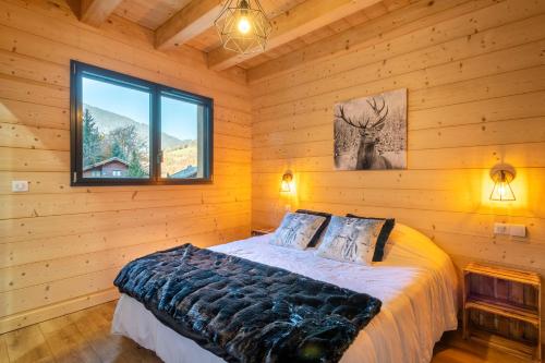 a bedroom with a bed in a log cabin at Chalet Frantz'y in Saint-Jean-d'Aulps