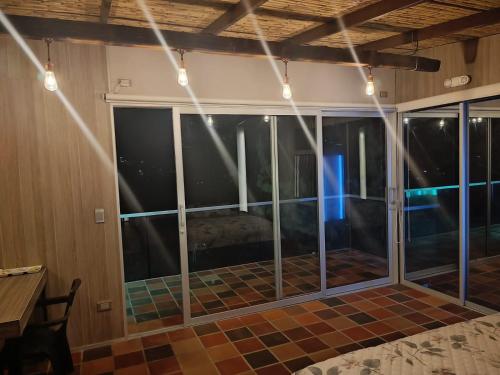 an empty room with glass windows and lights at Amonitas Glamping Deluxe in Tinjacá