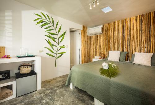 Un dormitorio con una cama verde con una planta. en El Encuentro Surf Lodge, en Cabarete
