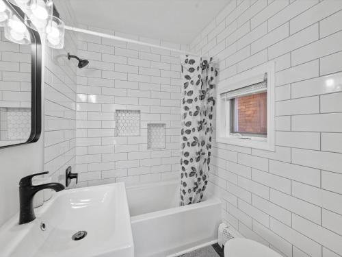 Baño blanco con lavabo y bañera en Shadyside, Pittsburgh, Modern and Bright 1 Bedroom Unit4 with Free Parking en Pittsburgh