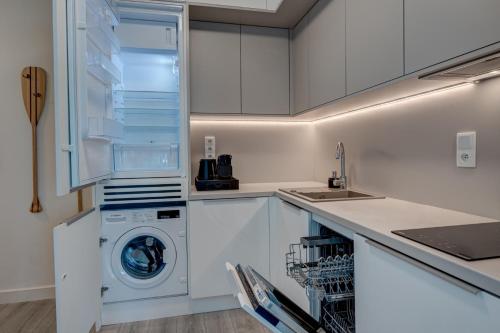 Una cocina blanca con lavadora y secadora. en Privilege Apartment, en Międzyzdroje