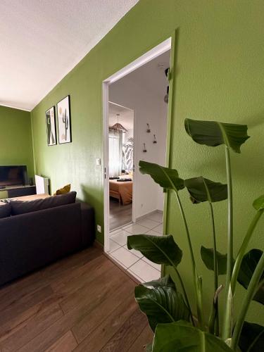 a living room with a couch and a mirror at L'Evasion Verte - Parking privé in Langres