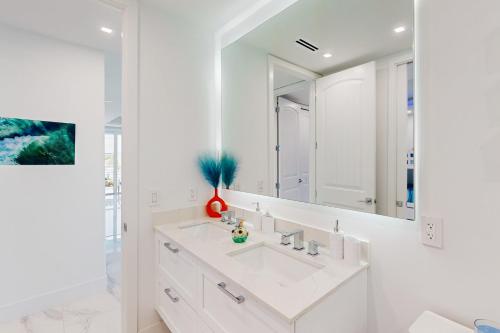 a white bathroom with a sink and a mirror at Afternoon Delight in Key Largo