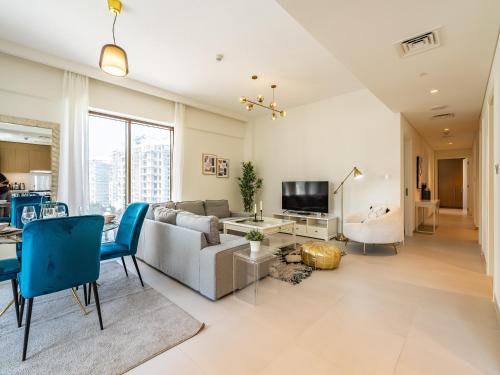 a living room with a couch and a table at Dubai Creek Gem, Stylish Condo With Two Balconies in Dubai