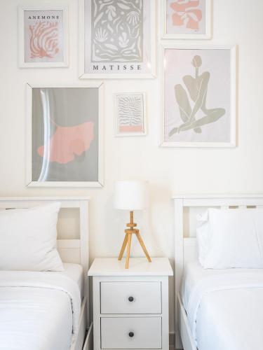 two beds in a bedroom with pictures on the wall at Dubai Creek Gem, Stylish Condo With Two Balconies in Dubai