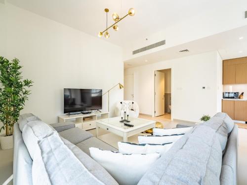 a living room with a couch and a tv at Dubai Creek Gem, Stylish Condo With Two Balconies in Dubai