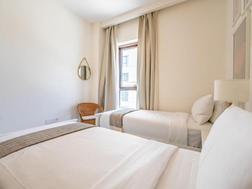 a hotel room with two beds and a window at Dubai Creek Gem, Stylish Condo With Two Balconies in Dubai