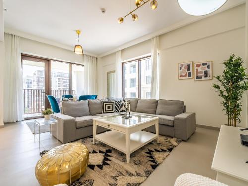 a living room with a couch and a table at Dubai Creek Gem, Stylish Condo With Two Balconies in Dubai