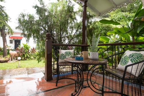 a patio with a table and chairs on a porch at Sashas Holiday Village in Vagator