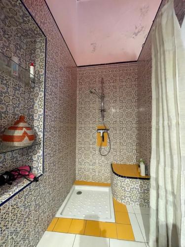 a bathroom with a shower and a bath tub at Riad Sidi Magdoul in Essaouira