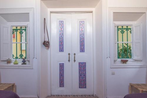 a white door with stained glass windows in a room at Riad Sidi Magdoul in Essaouira