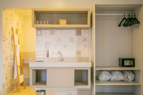 uma cozinha com um lavatório e uma prateleira em Pousada Villa Di Enzo em Ubatuba