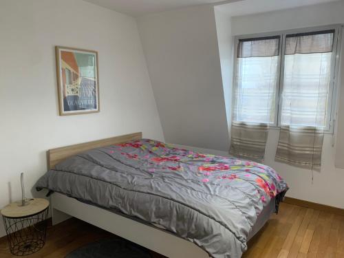 1 dormitorio con 1 cama y 2 ventanas en Deauville vue port centre ville, en Deauville