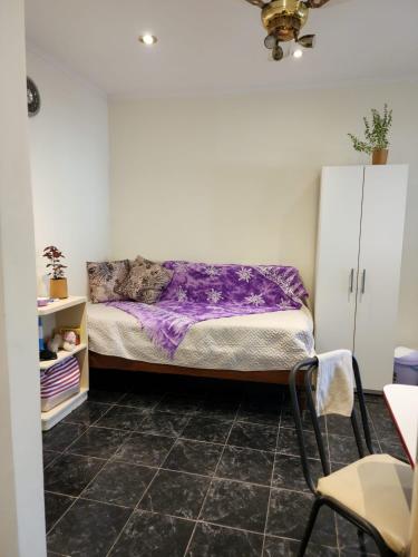 Un dormitorio con una cama con sábanas moradas. en Departamento en la "costa-Santa Teresita" 905 en Santa Teresita