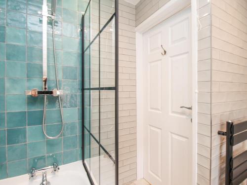 a bathroom with a shower and a glass door at Bay Cottage in Weymouth