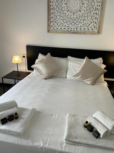 a white bed with two towels on top of it at Brignole Rooms in Genova