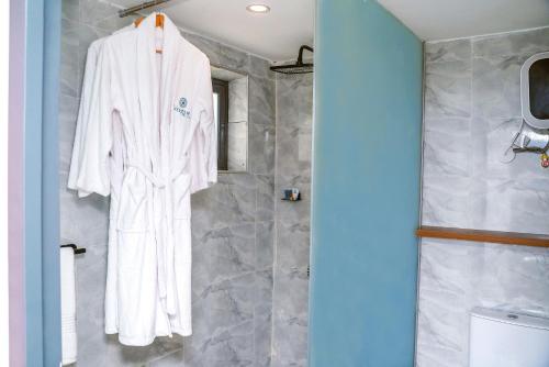 a white robe hanging on a wall in a bathroom at Vogue Beach Resort in Lagos