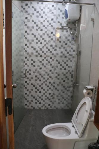 a bathroom with a toilet and a shower at Vườn Trà HomeStay Măng Đen in Kon Von Kla