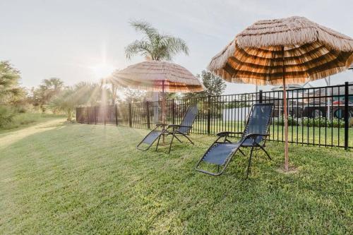 two chairs and two umbrellas in a yard at steve and cori's tropical king suite 2 in North Port