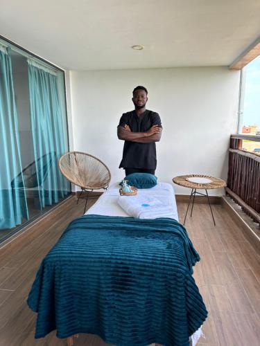 a man sitting on a bed in a room at Vogue Beach Resort in Lagos