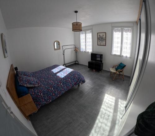 a bedroom with a bed and a television in it at Gîte des quatre saisons in Thilay