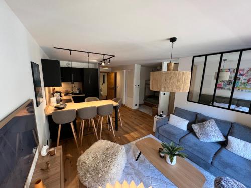 Il comprend un salon décloisonné et une cuisine avec un canapé bleu. dans l'établissement Très bel appartement au gets, aux Gets