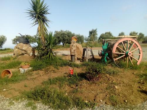 a garden with a wooden wagon and a palm tree at B&B Il Giardino di Circe - Filadelfia (VV) in Filadelfia