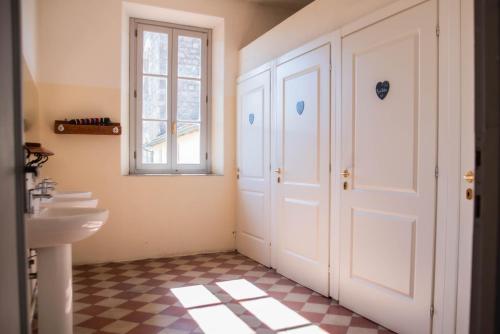 Ostello di Camaiore في كامايوري: حمام مع مغسلة وباب أبيض