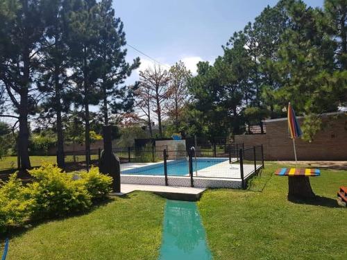- une piscine dans une cour à côté d'un parc dans l'établissement CABAÑAS HORNERO, à San José del Rincón