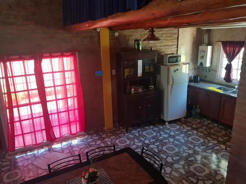 Il comprend une cuisine équipée d'un réfrigérateur blanc et 2 fenêtres. dans l'établissement CABAÑAS HORNERO, à San José del Rincón