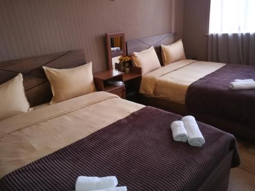 two beds in a hotel room with towels on them at Golden Gate in Akhaltsikhe