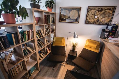 a room with two chairs and a book shelf at Capsule Hostel Logistic Vilnius in Vilnius