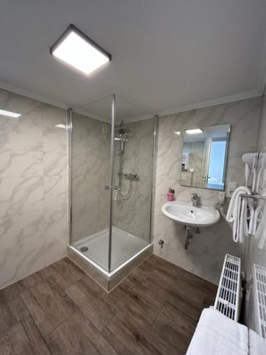een badkamer met een douche en een wastafel bij Rheinischer Hof Appartements in Leverkusen