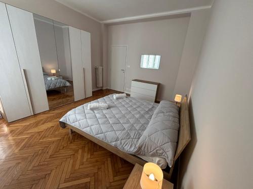 een slaapkamer met een groot bed en een houten vloer bij Xiridia House in Turijn