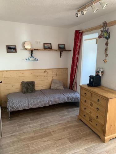 a bedroom with a bed and a dresser in a room at ski-in ski-out 118 in Val Thorens