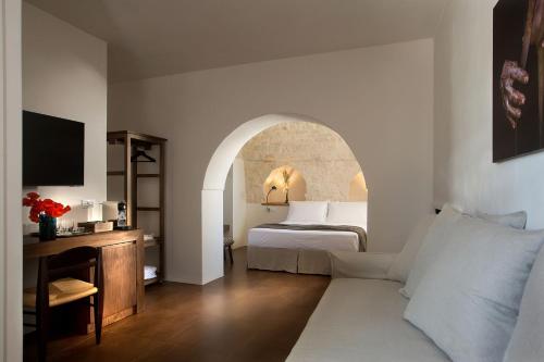 a hotel room with a bed and a couch at Ddò Relais di Puglia in Ostuni