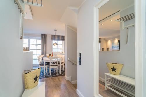 a living room with a table and a dining room at Appartement Lachmöwe - Nicolinenhof in Wenningstedt