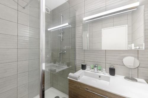 une salle de bain blanche avec un lavabo et un miroir dans l'établissement Aux portes de Bordeaux El Pablo MindUrGuest, à Floirac