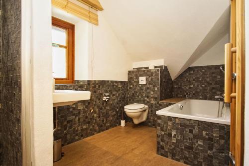 a bathroom with a sink and a toilet and a tub at komfortables Haus mit Kamin, Sauna, Garten und Terrasse - Ferienhaus Windhuus in Wiek auf Rügen 