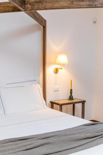 a bedroom with a white bed and a table at Ddò Relais di Puglia in Ostuni
