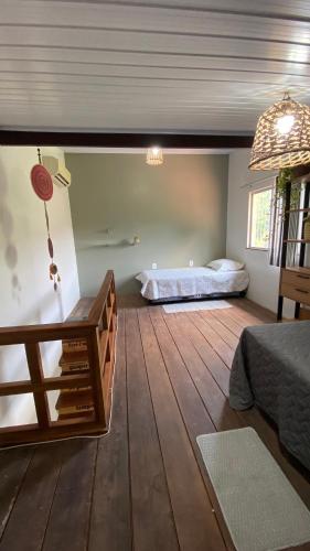 a room with two beds and a wooden floor at Casa Amarela Alter in Alter do Chao