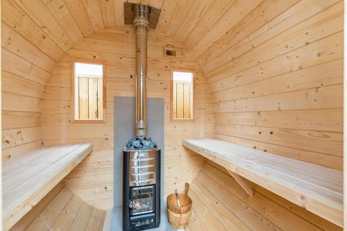 a wooden sauna with two benches and a stove at MB Guesthouse in Grímsnes og Grafningshreppur