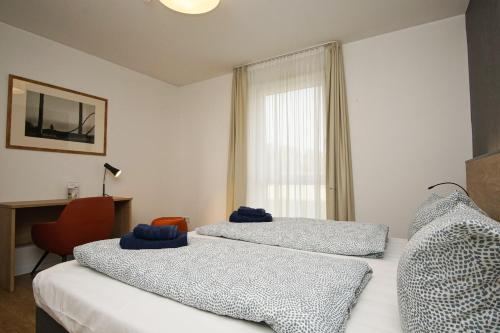 two beds in a room with a window at moderne Ferienwohnung in ruhiger Lage mit Terrasse - Wreecher Idyll FeWo 02 in Wreechen
