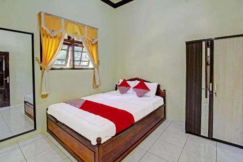 1 dormitorio con cama y ventana en OYO 91177 Desa Wisata Duren Sari, en Tasikmadu