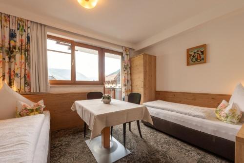 a hotel room with two beds and a table at Aparthotel Acksteiner in Sankt Anton am Arlberg