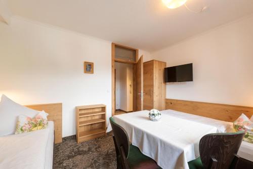 a room with a table with chairs and a tv at Aparthotel Acksteiner in Sankt Anton am Arlberg