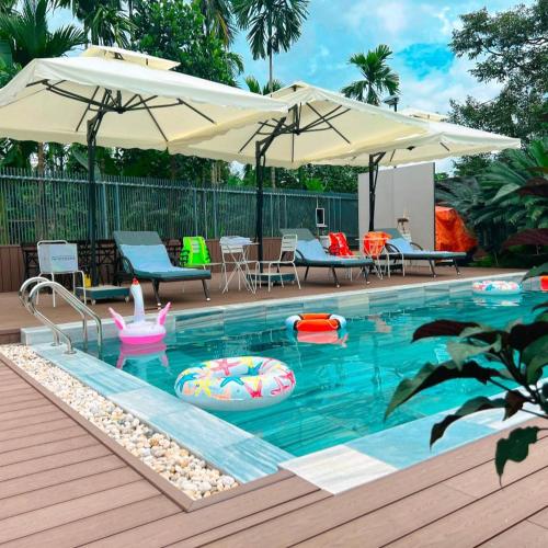 a pool with umbrellas and chairs and a swimming pool at Chang House BMT 